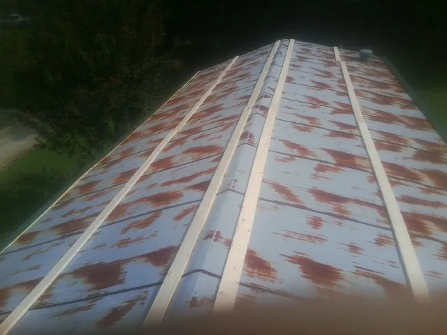 Rusted metal roof panels with new wood purlins before replacement — Storm Damage Roof Repair in Menan by Roofing Brothers