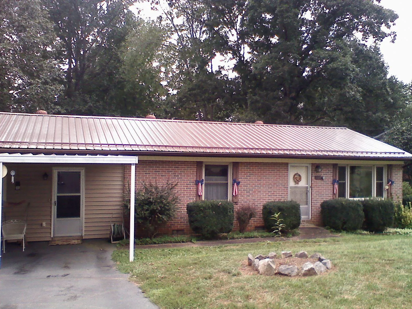 Bronze metal roof and carport on a brick ranch home — Roof Repair work by our crew in Menan